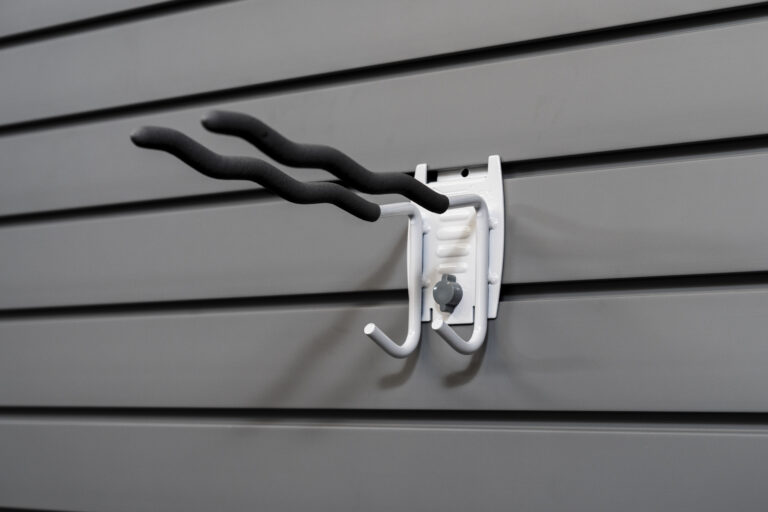 Multi-purpose tool hook on slatwall holding various items